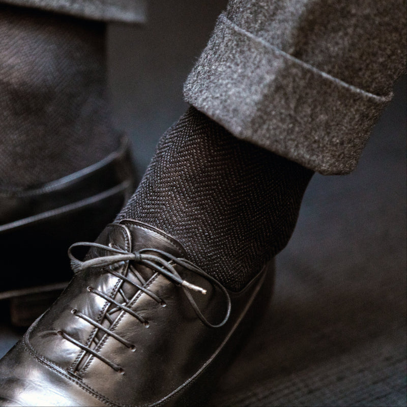 Chaussettes à motif chevrons de couleurs noir et gris, en 100% fil d'Écosse. Modèle pour homme de mi-bas (chaussettes hautes) de la marque Bresciani. Des chaussettes souples et douces, qui s'associent à des tenues élégantes et formelles. Pointures : du 39 au 49