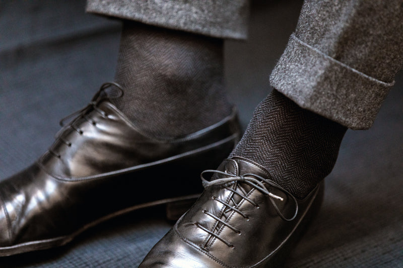 Chaussettes à motif chevrons de couleurs noire et grise, texture légèrement chinée, en 100% fil d'Écosse. Modèle de mi-mollet (courtes) pour homme de la marque Bresciani. Fines et légères. Pointures : du 39 au 45