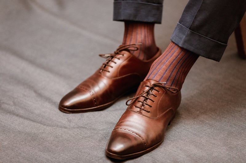 Chaussettes marron avec une côte bleu, vanisées, en 100% fil d'Écosse. Modèle pour homme de mi-bas (chaussettes hautes) de la marque Bresciani. Épaisseur fine pour des chaussettes légères mais durables et un toucher net. Conviennent à des chaussures et des tenues habillées. Pointures :  du 39 au 49