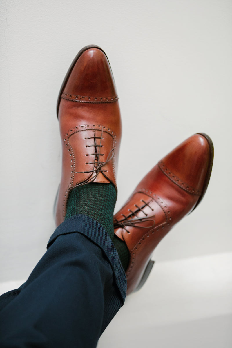 Chaussettes au motif pied-de-poule, couleur bleu marine et vert académie, en 100% fil d'Écosse. Modèle pour homme de mi-bas (chaussettes montantes jusque sous le genou) de la marque Mazarin. S'accordent très bien avec des tenues foncées. Pointures : du 39 au 46