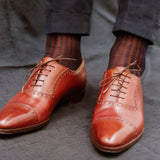 Chaussettes couleur bleu marine avec des côtes couleur marron cuivre en 100% fil d'Écosse. Modèle de mi-bas ( chaussettes hautes) pour homme de la marque Bresciani. Fabriquées en Italie. Fines, agréables à porter et avec une très bonne durabilité. Se portent avec une tenue habillée. Pointures : du 40 au 47.