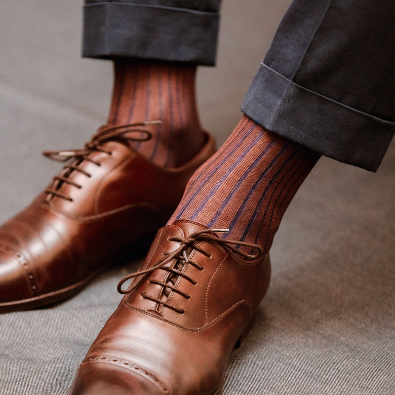 Chaussettes marron avec une côte bleu, vanisées, en 100% fil d'Écosse. Modèle pour homme de mi-bas (chaussettes hautes) de la marque Bresciani. Épaisseur fine pour des chaussettes légères mais durables et un toucher net. Conviennent à des chaussures et des tenues habillées. Pointures :  du 39 au 49