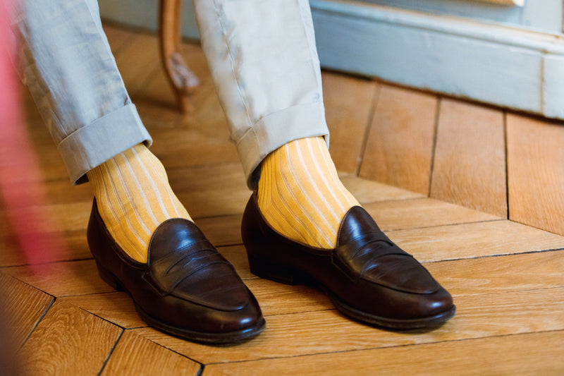 Chaussettes jaune avec des rayures blanches, en 100% fil d'Écosse. Modèle pour homme de mi-bas (montantes jusqu'au genoux) de la marque Bresciani. Des chaussettes douces, durables et originales qui s'associent très bien avec un jean ou un pantalon beige. Pointures : du 39 au 45