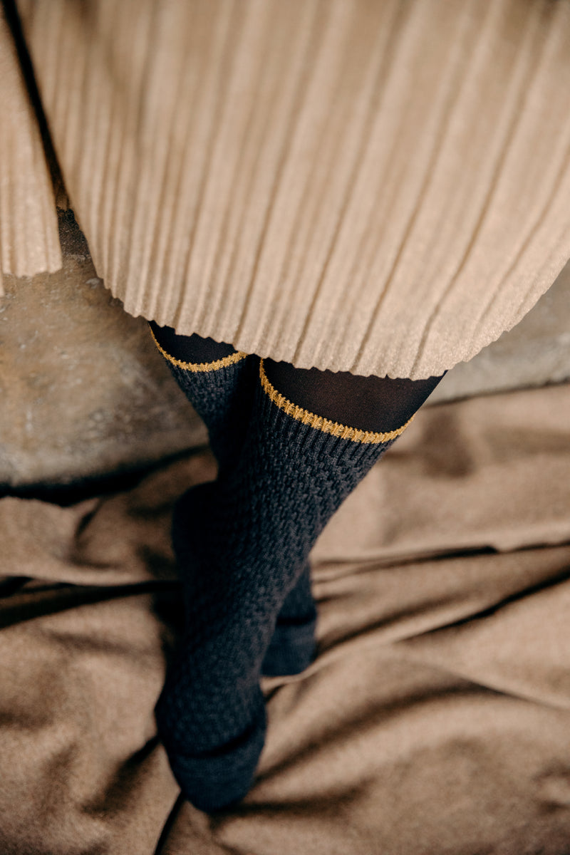 Chaussettes de couleur grise en 90% laine, 8% polyamide, 2% élasthanne. Paire de chaussettes courtes, aussi appelées mi-mollet pour femme, de la marque Daphné. Le motif "Panama" donne un effet texturé natté. Épaisses, elles retiennent bien la chaleur. Pointures : du 36 au 41  