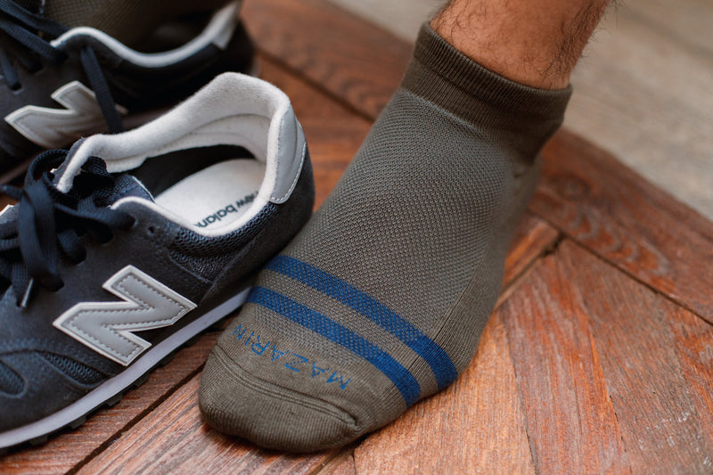 Chaussettes de sport très courtes de couleur kaki au motif vintage, avec des bandes bleues. Modèle de chaussettes unisexe par la marque Mazarin. En 80% coton, 18% polyamide et 2% d'élasthanne. Confortables, résistantes et très aérées. Pointures : du 36 au 45. 