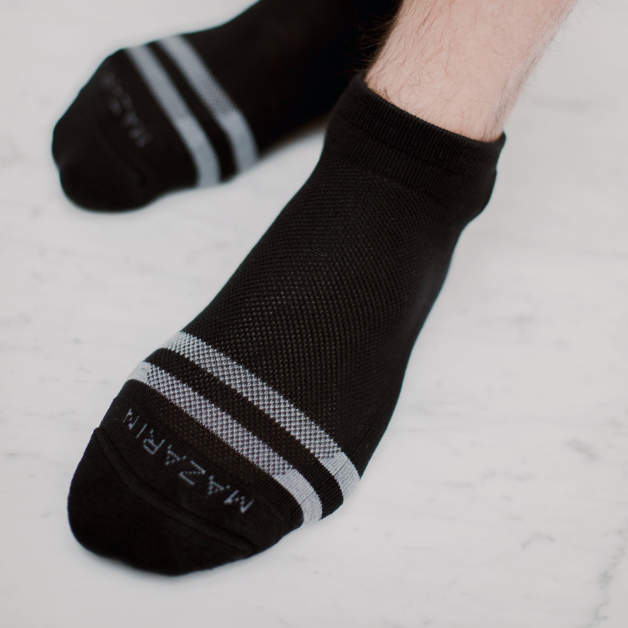 Chaussettes noires au motif vintage, avec des bandes gris clair. Modèle de chaussettes de sport courte unisexe, par Mazarin. En 80% coton, 18% polyamide et 2% élasthanne. Chaussettes respirantes, confortables, douces. Pointures : du 36 au 45 